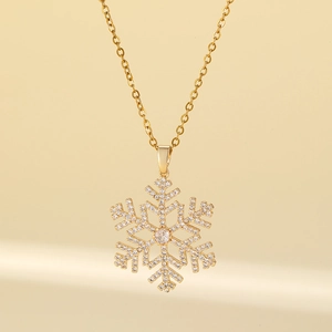 Elegant gold snowflake pendant necklace with diamonds for women in warm lighting