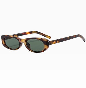 Dettaglio di occhiali da sole ovali vintage tartarugati con lenti verde scuro