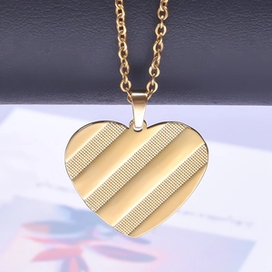 Detailed view of heart-shaped gold-plated necklace pendant with diagonal striped texture