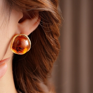 Close-up of vintage resin earrings with gold metal wrap on a female model