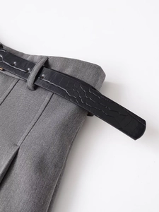 Detailaufnahme der grauen Hose mit schwarzem Gürtel in Krokodiloptik und Metallschnalle