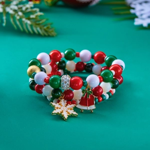 Dettaglio dei bracciali natalizi a strati con perline, fiocchi di neve e campanelli