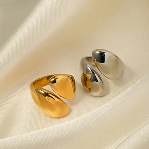 Polished 18k gold and silver stainless steel asymmetric open rings on silk fabric