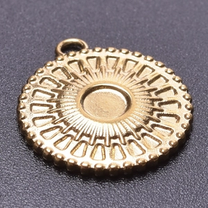 Macro detail of 18k gold plated sunburst pendant with embossed radiating texture