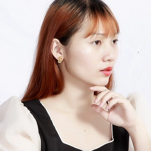 Elegant gold-plated Hamsa Hand earrings with rhinestones shown on a female model