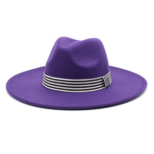 Detail of purple wide brim wool fedora hat featuring a black and white striped ribbon band