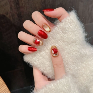 Faux ongles de Noël rouge et doré avec nœuds 3D et détails scintillants festifs