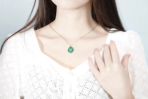 Detail of gold link chain necklace featuring a green malachite Taurus zodiac pendant