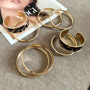 Detailed view of golden bracelet set featuring leopard print and slim metallic ring bands