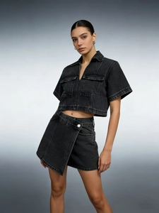 Detail of washed dark gray denim set featuring a cropped jacket and asymmetric mini skirt