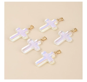 Five iridescent white glass cross pendants with gold rings on a beige background