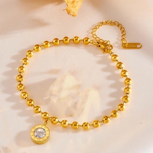 Detail view of golden stainless steel bracelet with Roman numeral zircon pendant