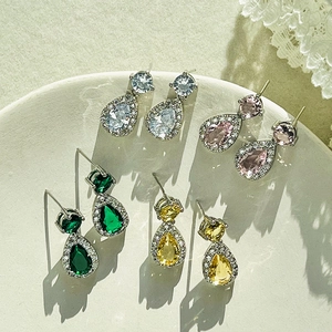 Luxury teardrop zircon drop earrings in white, pink, green, and yellow on a white plate