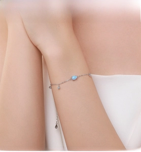 Détail d'un bracelet en argent S925 avec une opale bleu foncé sur le poignet d'un mannequin