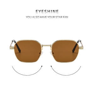 Detail of vintage small metal frame sunglasses with golden hexagonal trim and brown lenses