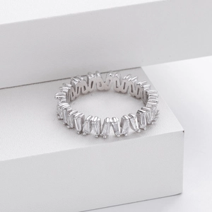 Macro detail of silver V-shaped ring with rectangle zircon stones on a white platform