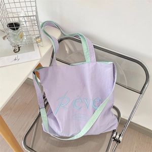 Detail of lavender and mint green tote bag featuring high-quality Rêve embroidery