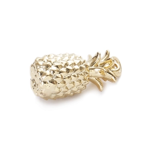 Macro detail of a golden pineapple charm with metal finish for DIY jewelry crafting