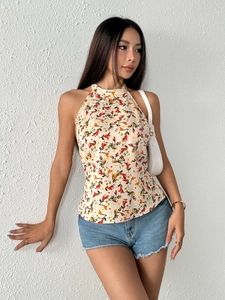Floral halter top with open back and cream floral print on a model with denim shorts