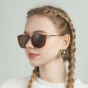 Kids leopard print sunglasses and gold hoop earrings on model in soft lighting