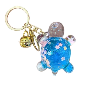 Llavero de tortuga luminosa con degradado azul-rosa y arena brillante para bolsos