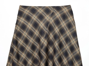 Gros plan sur le tissu à carreaux marron de la jupe avec dentelle et motif vichy