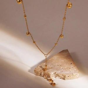Retro titanium steel gold beaded Y-necklace with elegant spheres on a minimalist stone base