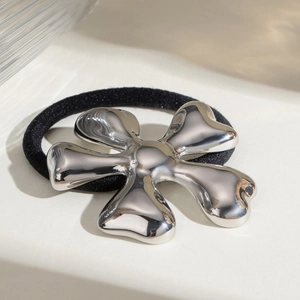 Detail of silver irregular flower metal charm on black high-elastic hair scrunchie