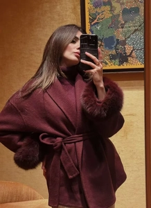 Close-up of wine red wool coat detail with matching fur cuffs and waist belt ties