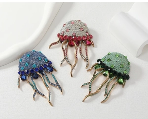 Detailed close-up of three sparkling jellyfish brooches with rhinestones and crystal tassels