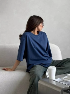 Dettaglio della maglietta in cotone blu navy lavato con design a spalle cadenti