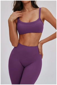 Dettaglio del set yoga viola con reggiseno sportivo a doppia tracolla e leggings a vita alta
