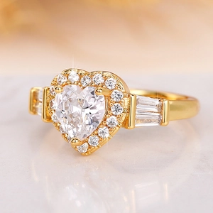 Dettaglio macro dell'anello con zircone a cuore e pietre baguette in oro