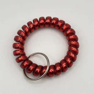 Close-up of a red matte spiral coil wristband keychain with a durable silver metal ring