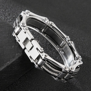 Macro shot of silver H-link stainless steel bracelet with wire rope details on black