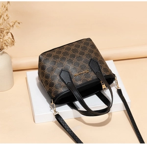 Detail der bedruckten Beuteltasche mit Metallbeschlägen auf geometrischen Requisiten