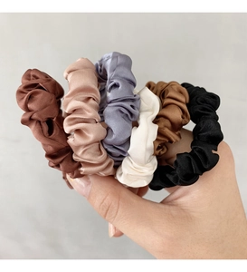 Dettaglio di elastici in seta satinata nei colori marrone rosa grigio bianco e nero