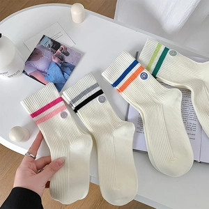 Detail of four pairs of ribbed sports socks with double stripes and smiley face patch