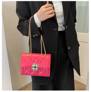 Detail of fuchsia quilted crossbody bag with gold chain strap and square metal lock