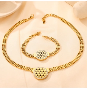 Détail de l'ensemble de bijoux en acier inoxydable doré avec des pendentifs arbre de vie