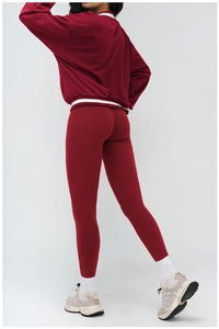 Detail view of burgundy V-neck sports sweatshirt with white stripe trim and high-waist leggings