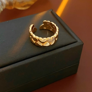 Detail of 18k gold plated open ring with interlaced heart patterns and zircon inlay