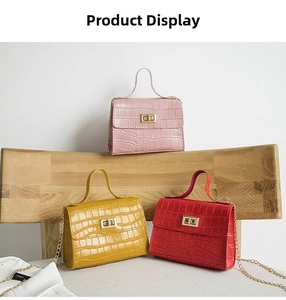 Detailed view of pink, yellow, and red crocodile pattern handbags with gold chain straps