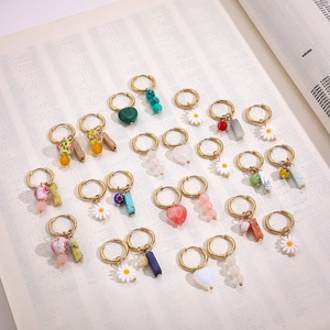 Various Chinese style heart and floral enamel gold hoop earrings on a vintage book