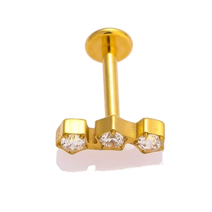Macro view of gold G23 titanium labret stud featuring three sparkling cubic zirconia