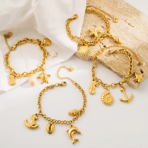 Detailed shot of gold ocean themed charm bracelets featuring seahorse and starfish charms
