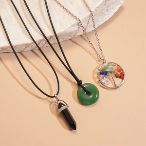 Détail de trois colliers ethniques en résine et pierre avec pendentif Arbre de Vie filaire