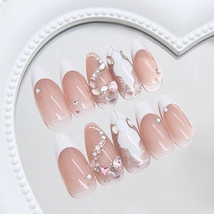 Sparkling almond press-on nails with silver glitter, rhinestones and pearls on tray