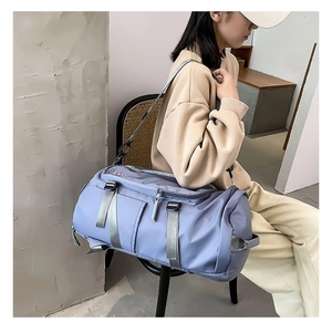 Detail of blue nylon travel bag showing durable handles and side zipper pocket