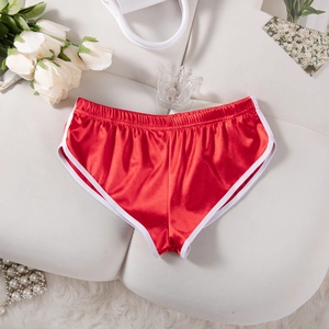 Dettaglio dei pantaloncini sportivi in raso rosso con bordo bianco ed elastico in vita su decori